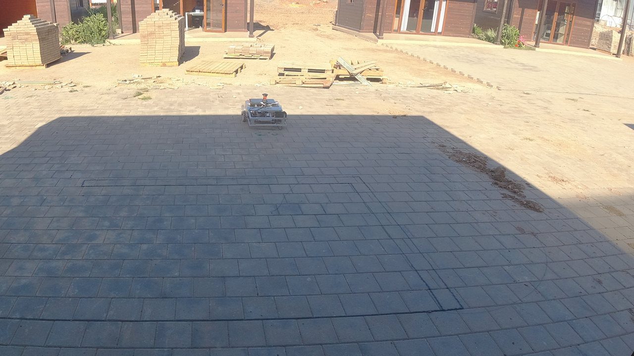 The COROSOLS robot on a real pilot site with freshly traced layout lines on the pavement.